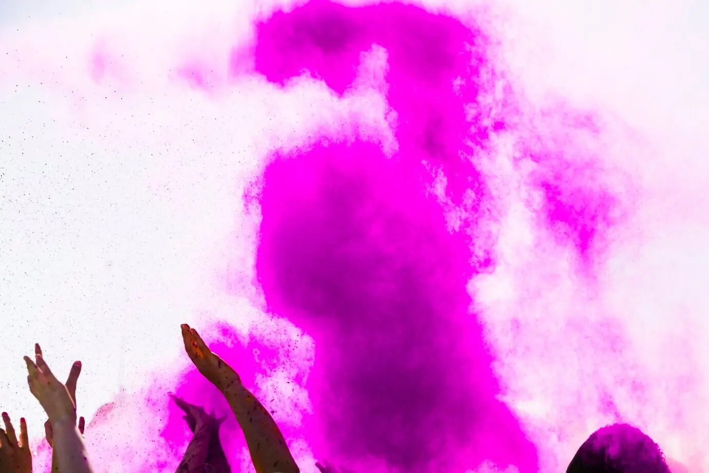 Explosion pinker Holi-Farbe mit Händen der Menschenmenge